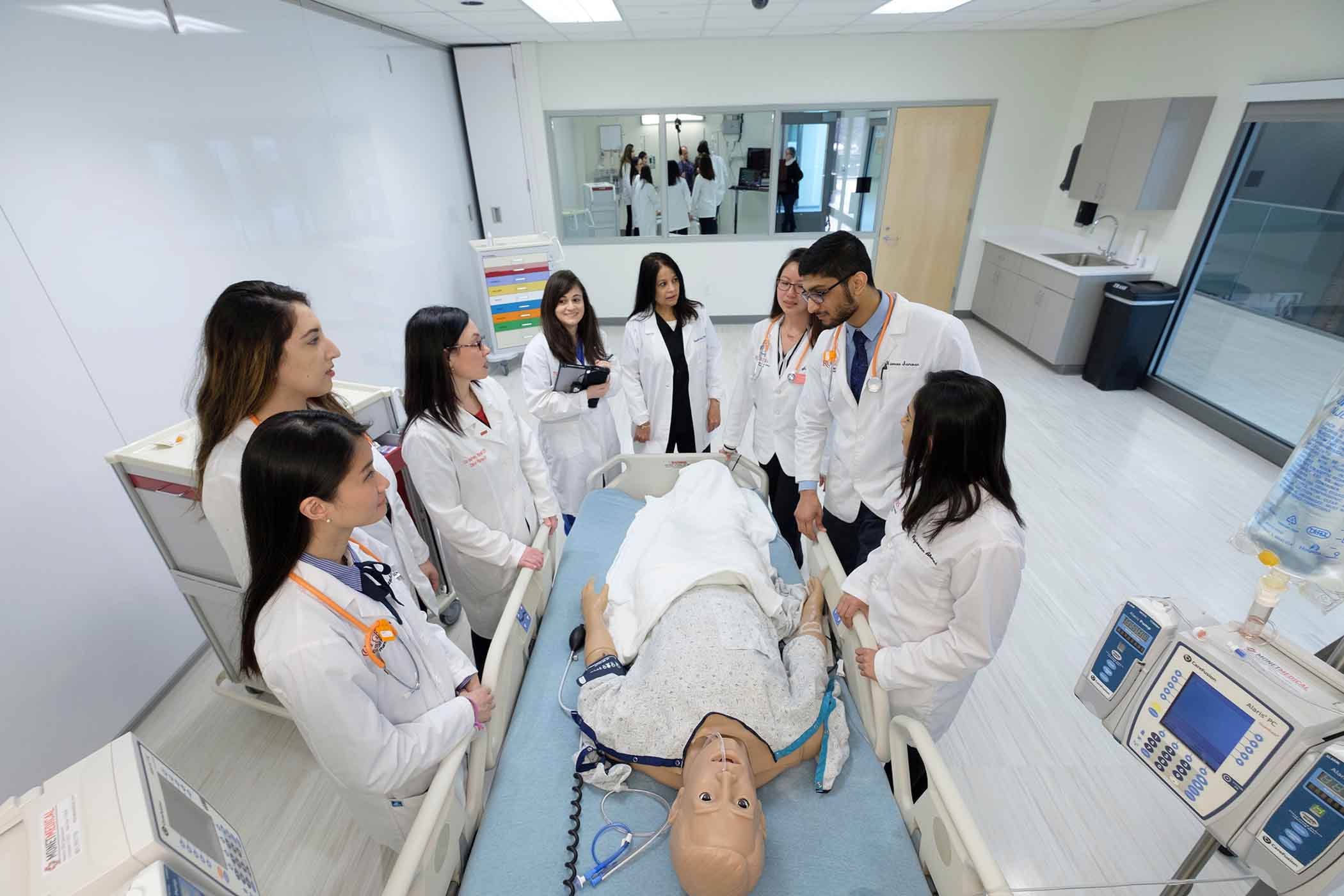 Photo of student standing around a patient simulation mannequin